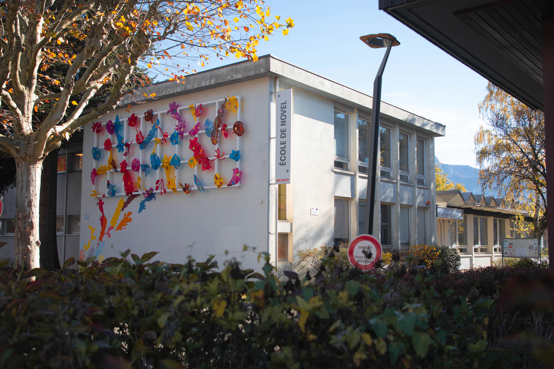 Façade d'une école primaire à Annecy avec une installation artistique colorée sur le mur extérieur - Éducation et formation - Acteurs Annecy