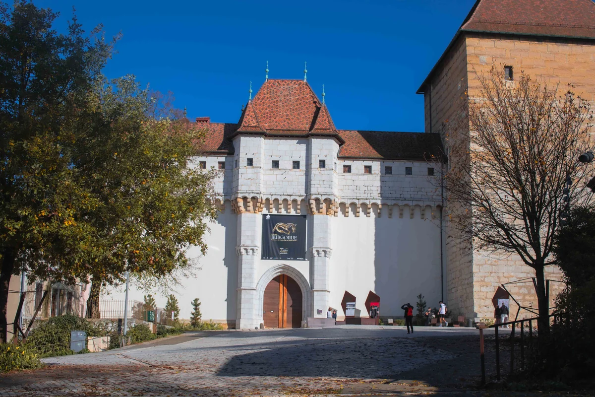 Porte fortifiée du château d'Annecy en pierre blanche avec toit rouge et tours - Patrimoine culturel et musée - Culture : un bien commun, pas un luxe - Acteurs Annecy