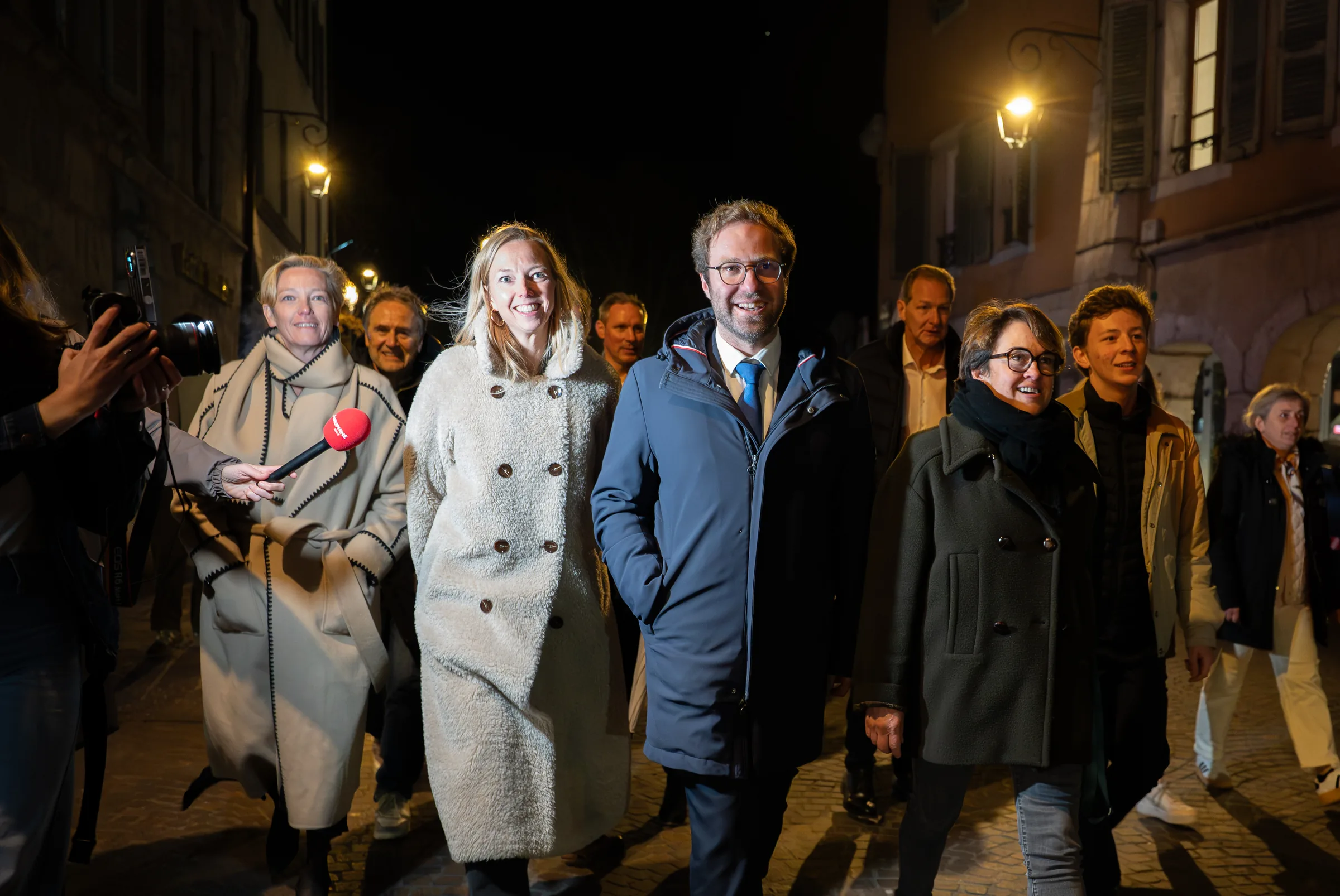 Antoine Armand entouré de son équipe et de soutiens dans les rues d'Annecy après la victoire aux municipales 2026