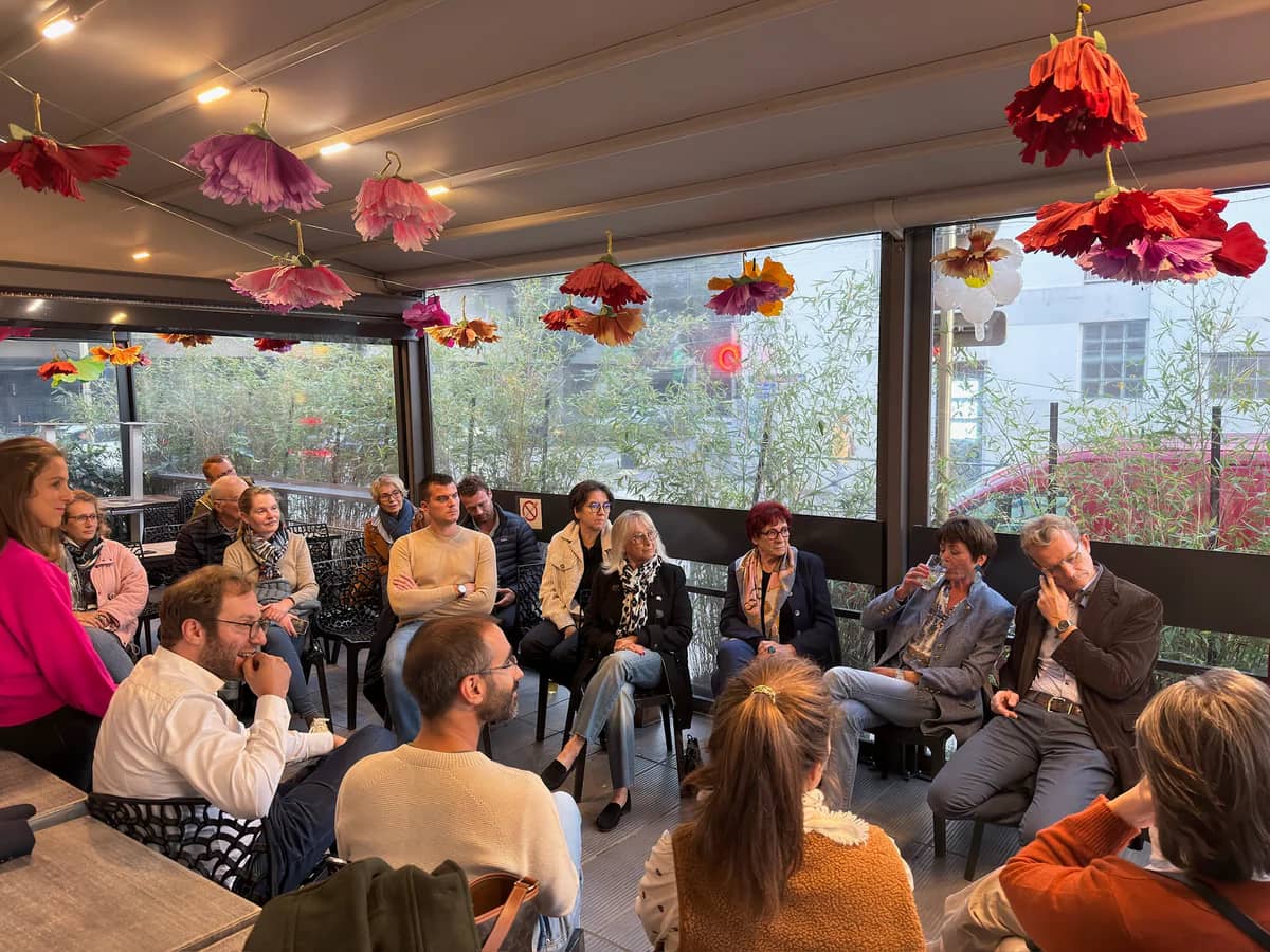 Réunion communautaire en intérieur avec un groupe de personnes assises en cercle à Annecy - Porte-à-porte et écoute citoyenne - Acteurs Annecy