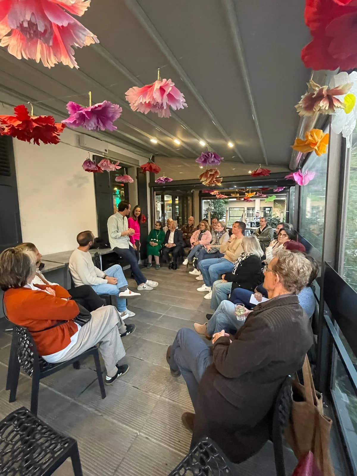 Salle collective en verandah, autour d'un groupe de personnes réunies pour une discussion participative à Annecy - Construction des mesures avec les habitants - Acteurs Annecy